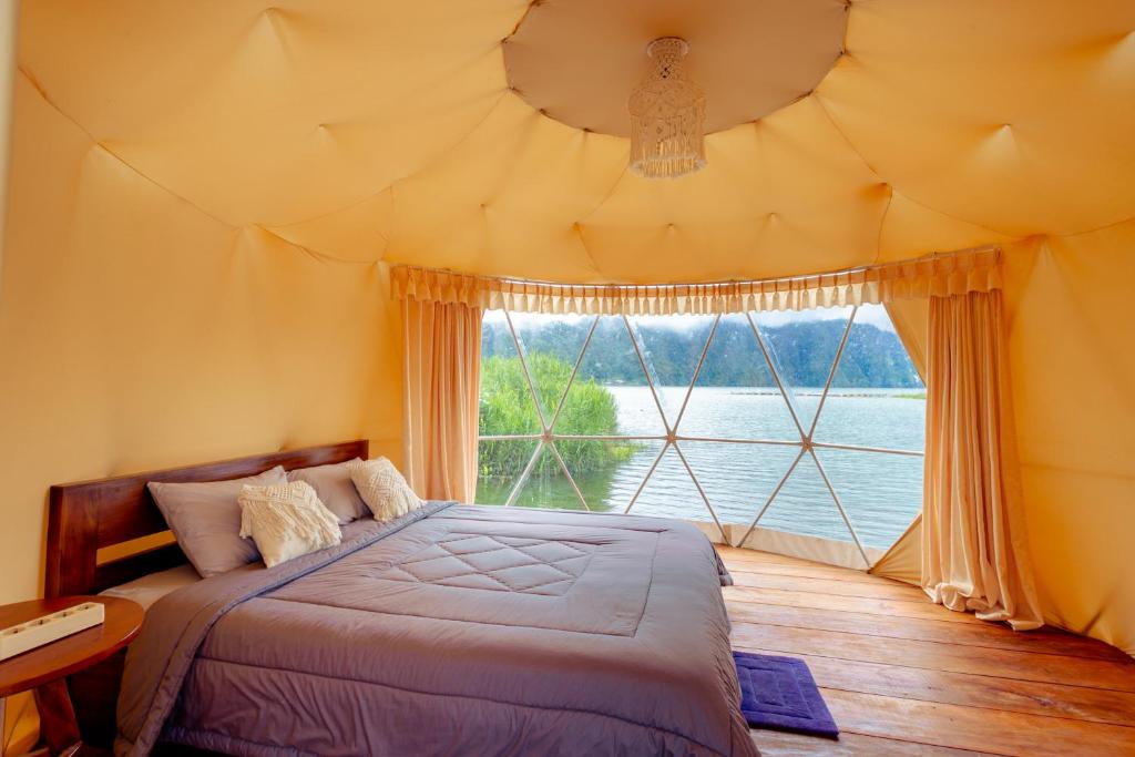 sypialnia z łóżkiem i dużym oknem w obiekcie Jempana View w mieście Kintamani