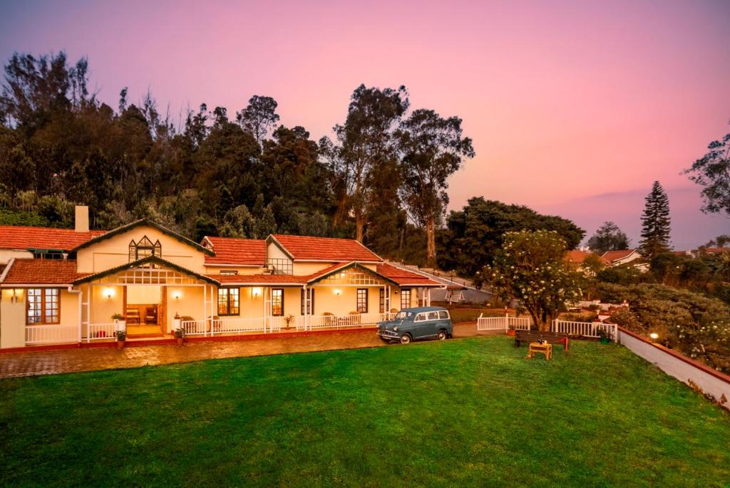 a house with a car parked in the yard at Rosewood by Nature Resorts in Ooty