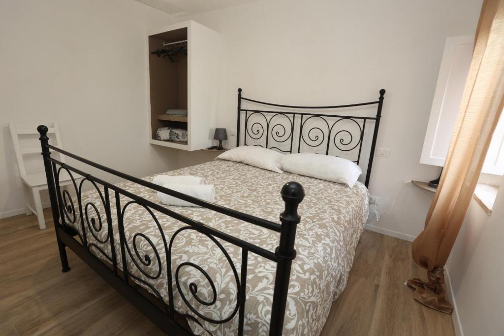 una camera da letto con un letto nero con lenzuola bianche di RelaxNelBorgo Marilyn a Formello