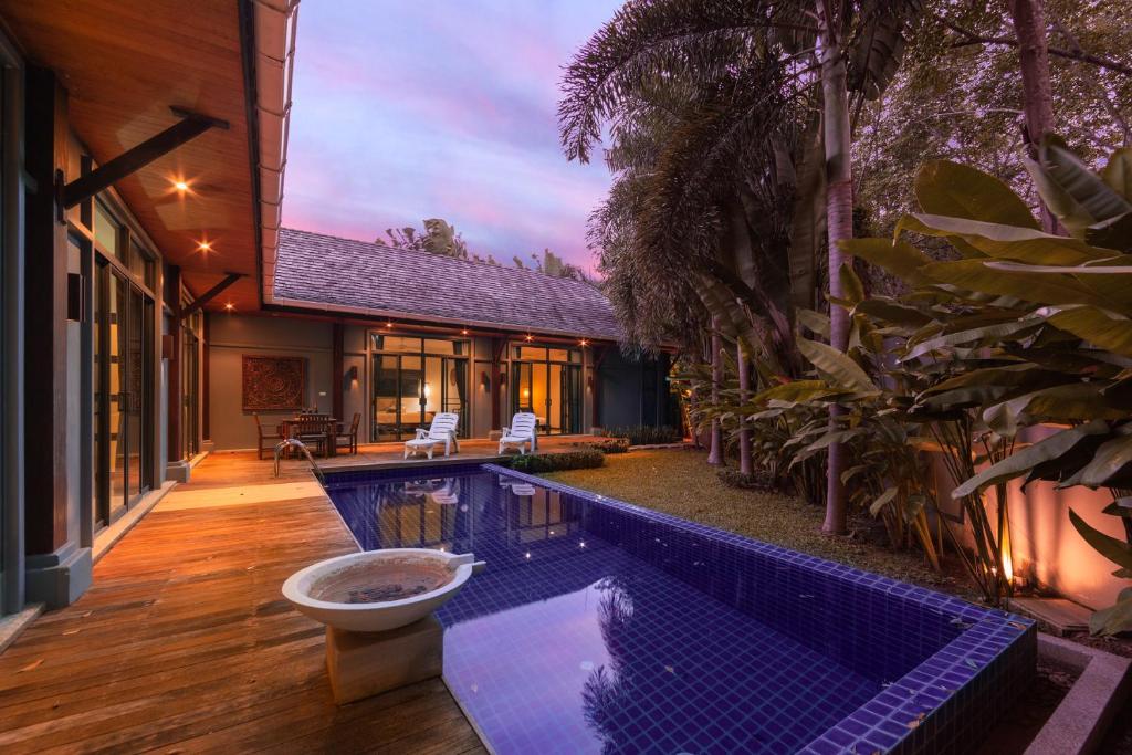 a house with a swimming pool in front of a house at Saiyuan Estate by TropicLook in Rawai Beach