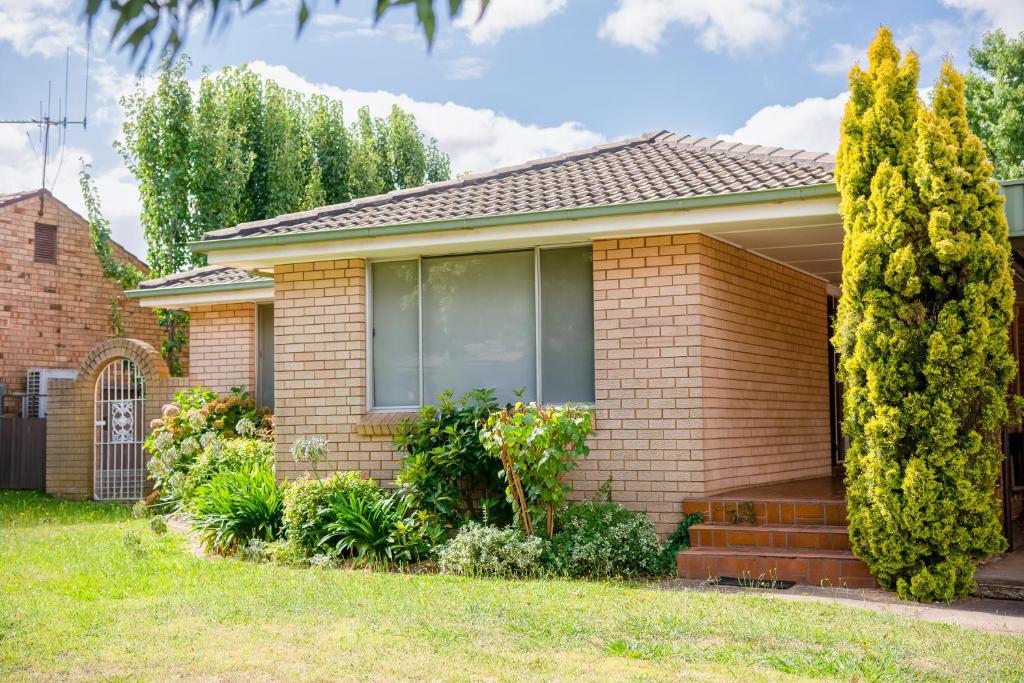 una casa de ladrillo con una ventana y arbustos en Dar Rahah, en Orange