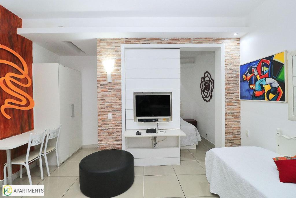 Studio silencioso para 3 pessoas em Copacabana في ريو دي جانيرو: غرفة معيشة فيها تلفزيون وغرفة فيها سرير
