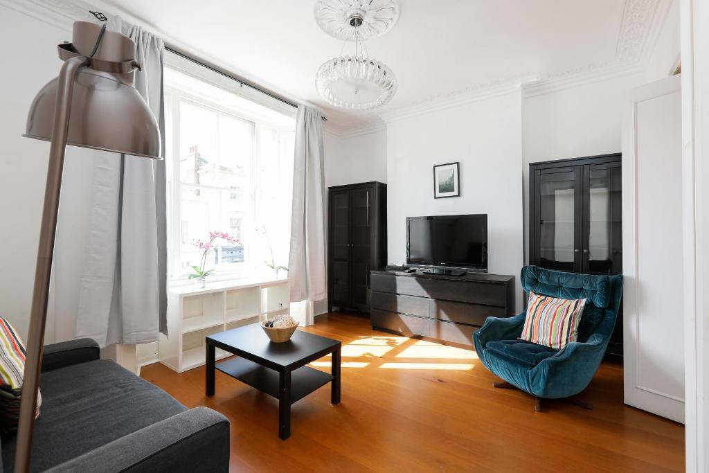een woonkamer met een bank, een stoel en een tv bij Fantastic Stays at Camden in Londen