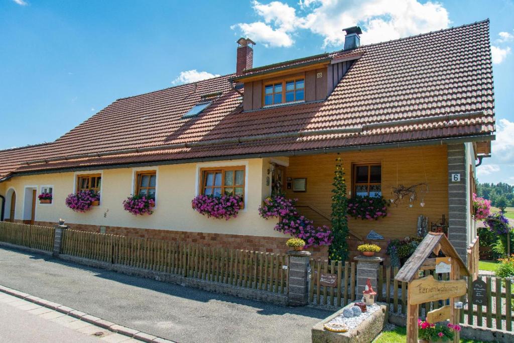 una casa con flores en las ventanas y una valla en Fewo Böhmerwaldblick en Waldmünchen