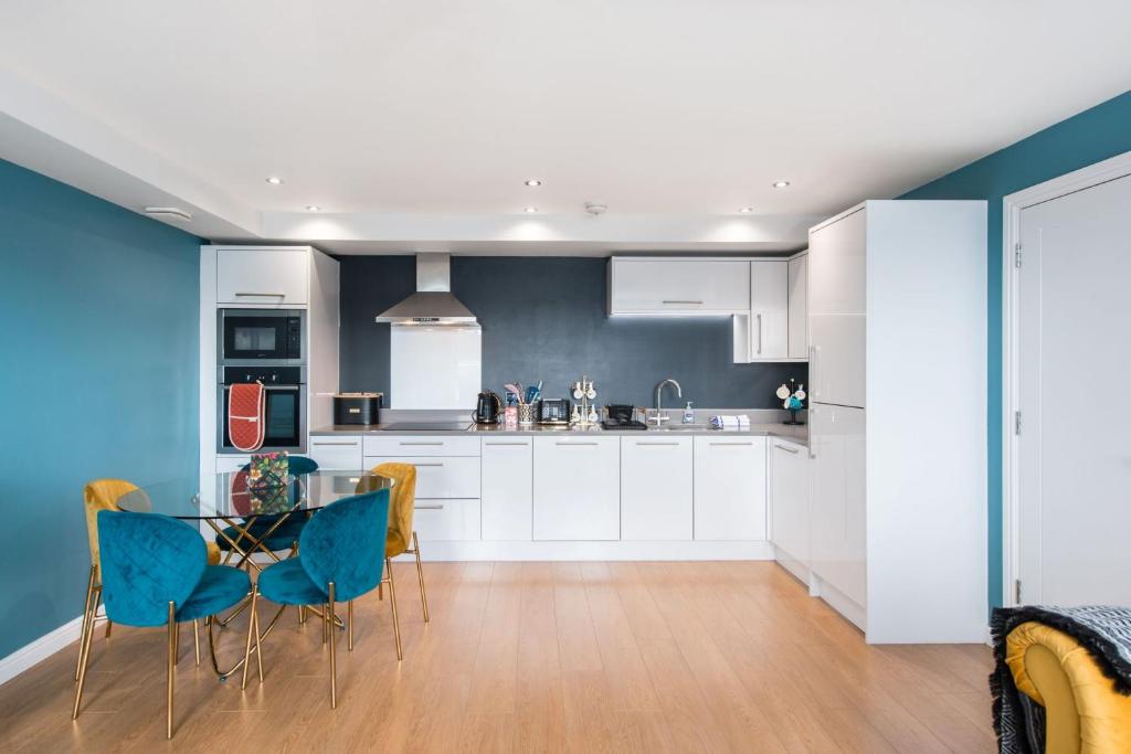 a kitchen with white cabinets and a table and chairs at 48 Annandale Street in Edinburgh