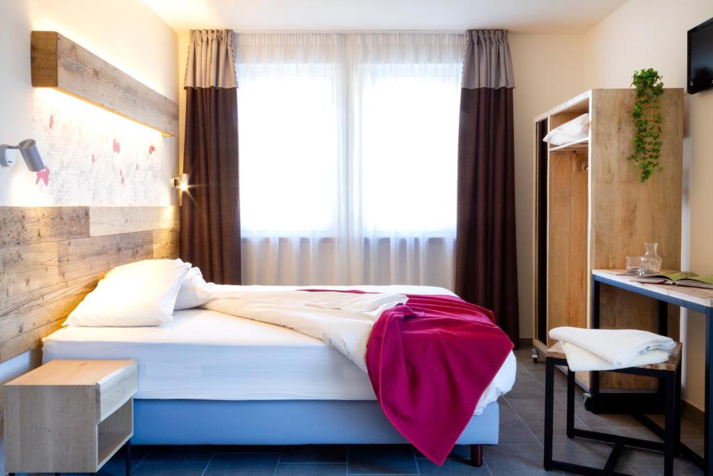 Hirondelle Locanda في أَويستا: غرفة نوم بسرير ومكتب ونافذة