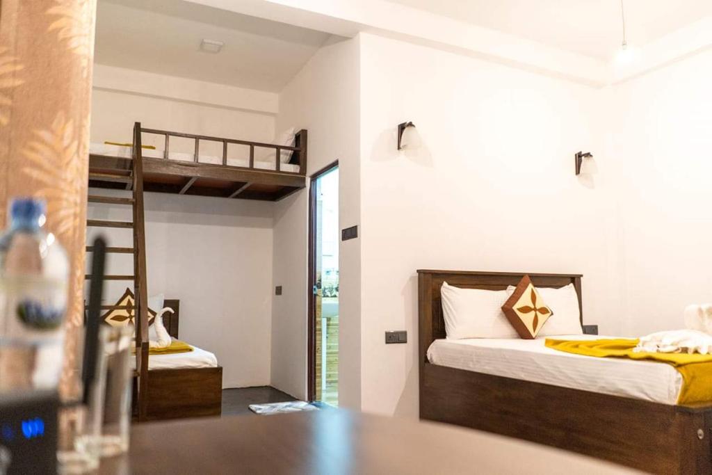 1 dormitorio con 2 literas y mesa en New green leaf resort, en Ella