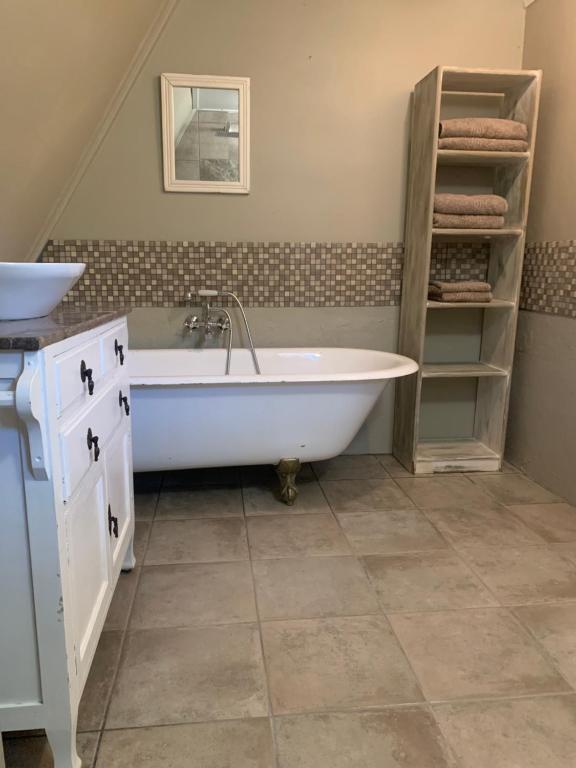 een badkamer met een bad en een wastafel bij Notting Hill Lodge in Balgowan