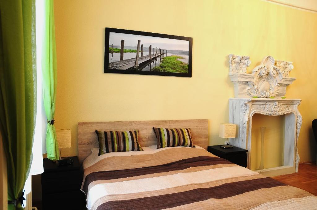 ブダペストにあるGreen Apple Apartmanのベッドルーム1室(ベッド1台付)が備わります。壁に絵が飾られています。