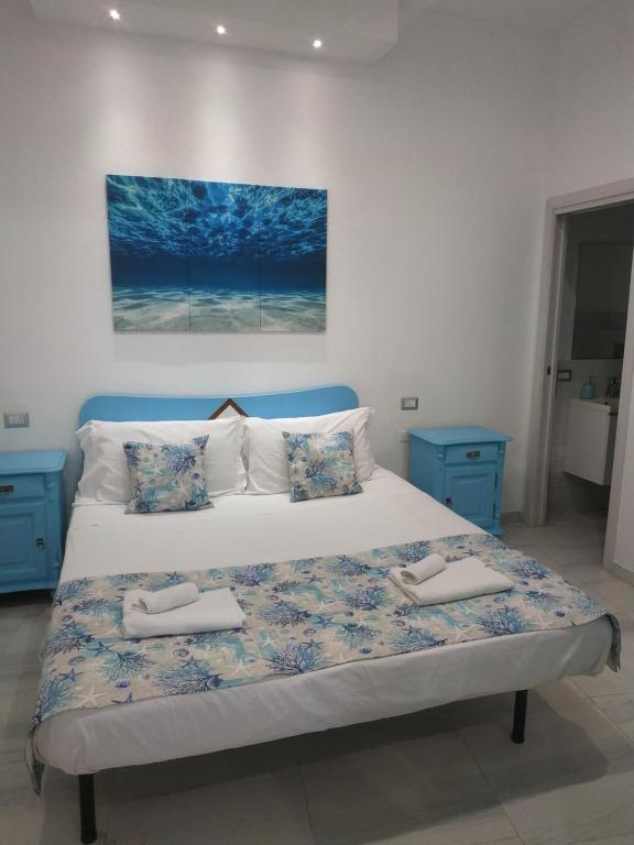 a bedroom with a large bed with two towels on it at Casa in borgo marinaro in Giardini Naxos