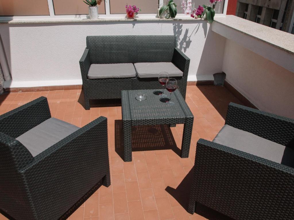 patio z 2 krzesłami, stołem i 2 krzesłami w obiekcie OPORTO GUEST Cedofeita Terrace w Porto