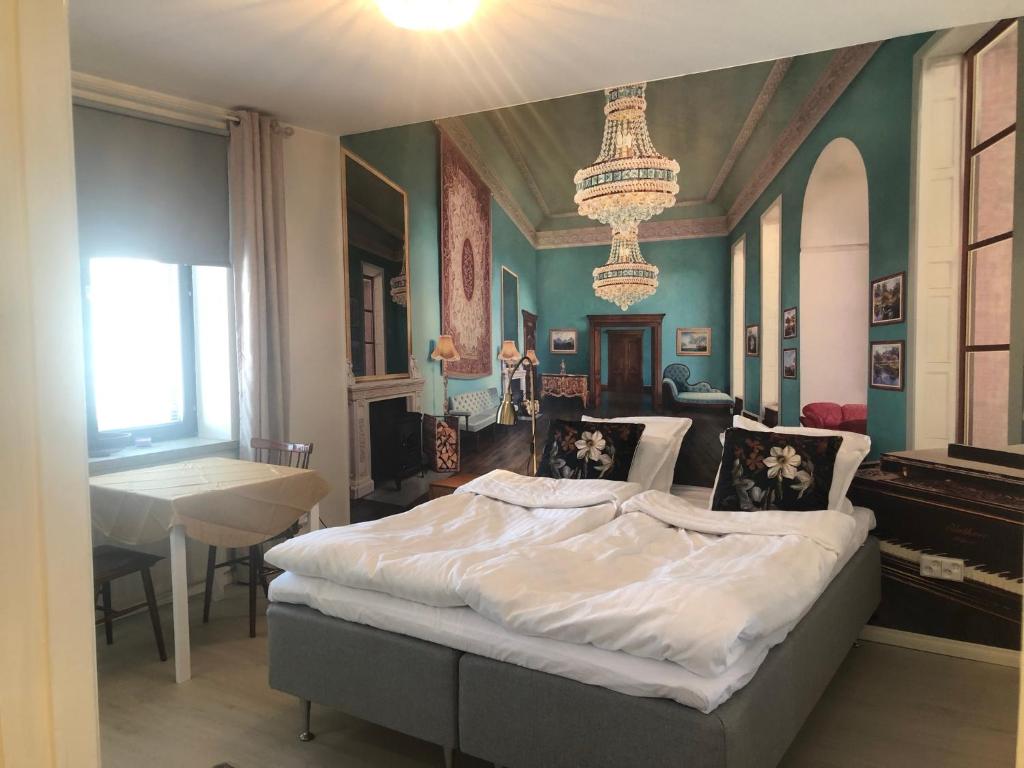 a bedroom with a large bed with a chandelier at Studio in the center with free private parking in Kemi