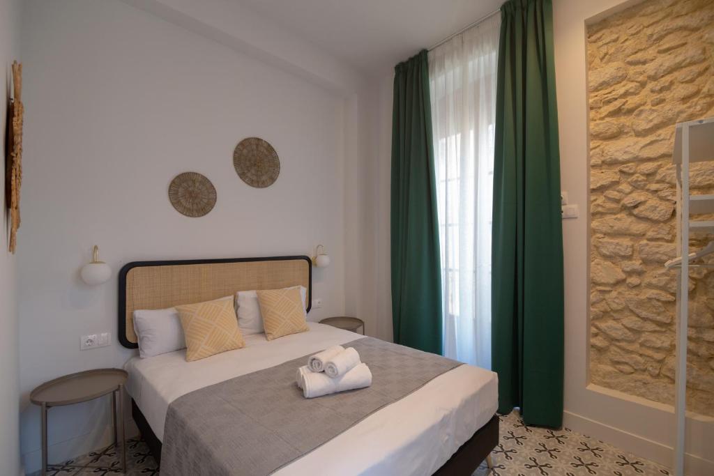 a bedroom with a bed with two towels on it at Apartamentos Teatro by Be Alicante in Alicante
