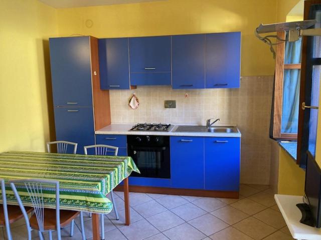 a kitchen with blue cabinets and a table and a sink at Residenza Graziella in Bobbio Pellice