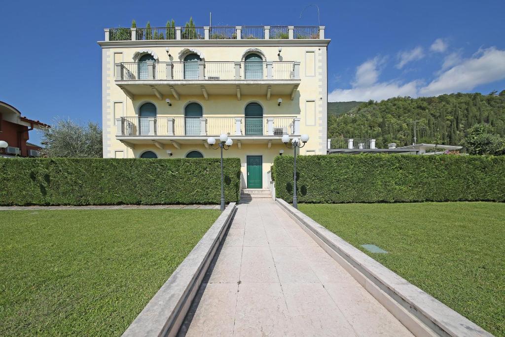 un gran edificio con una pasarela delante de él en Villa Bornico Margherita, en Toscolano Maderno