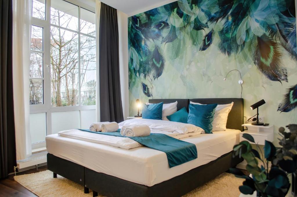 a bedroom with a bed with a large painting on the wall at HOMELY STAY Studio 9 in Munich