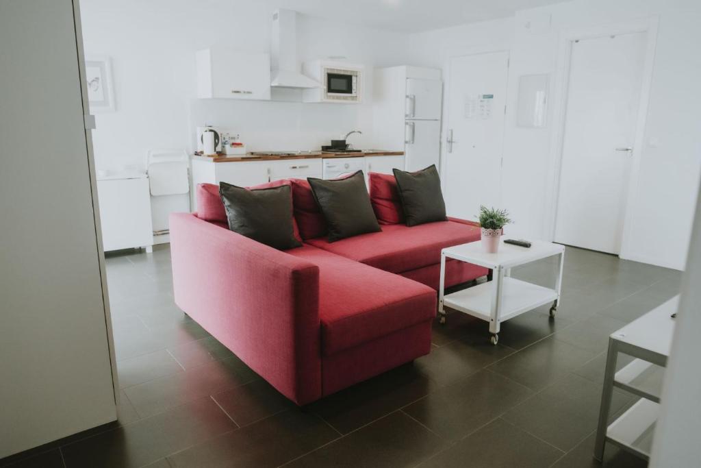 a red couch in a living room with a table at Apartamentos ZHR 2 in Zahara de los Atunes