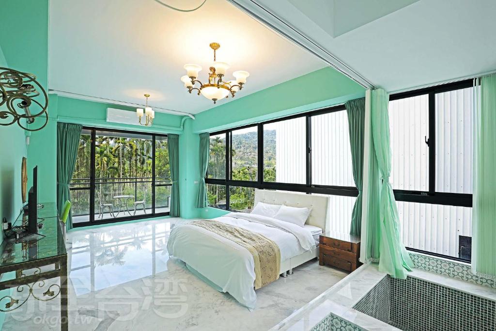 1 dormitorio con 1 cama y ventanas grandes en Mao Lan Mountain Holiday Villa, en Shan-tzu-chiao