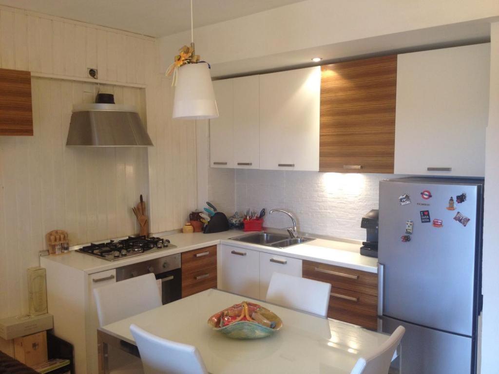 eine Küche mit einem Tisch und einem weißen Kühlschrank in der Unterkunft Confortevole appartamento a Camigliatello Silano in Camigliatello Silano