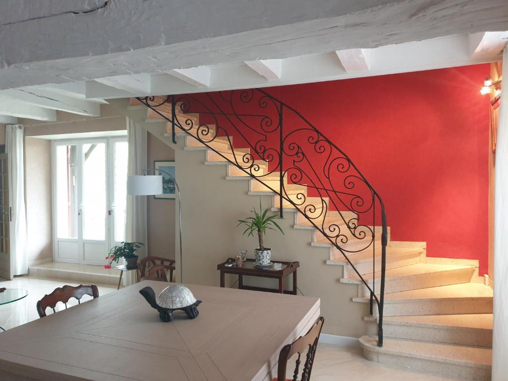 una escalera en una sala de estar con mesa de comedor y una mesa de comedor en Au Clos du Bourg en Blasimon