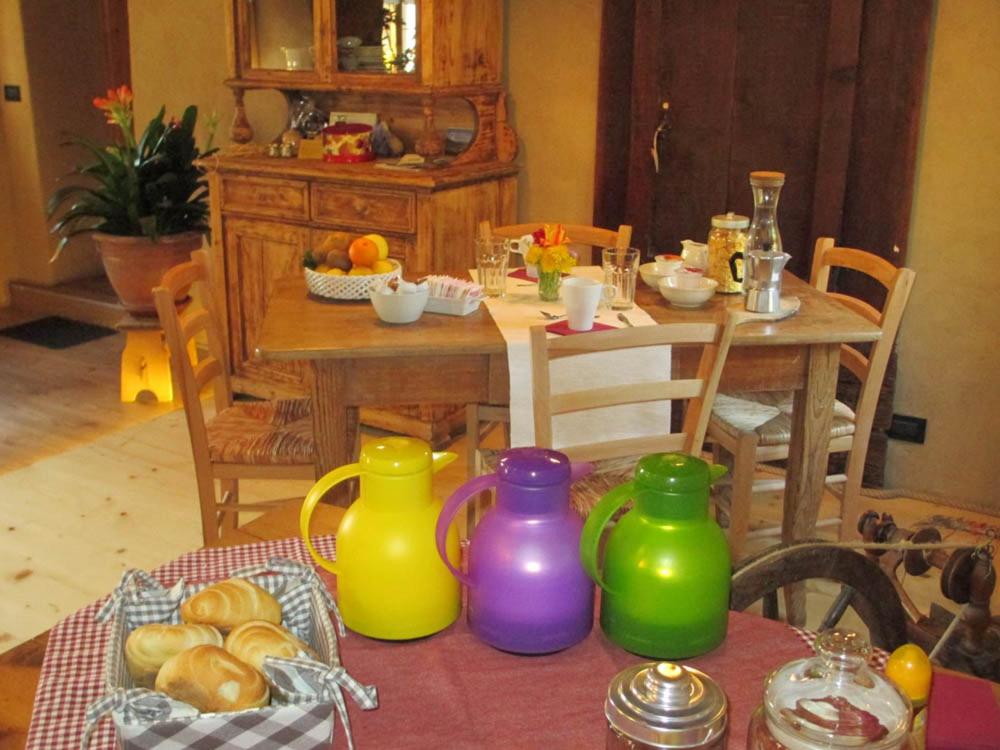 a dining room with a table withcolored vases on it at PANEERIPOSO in Pergine Valsugana