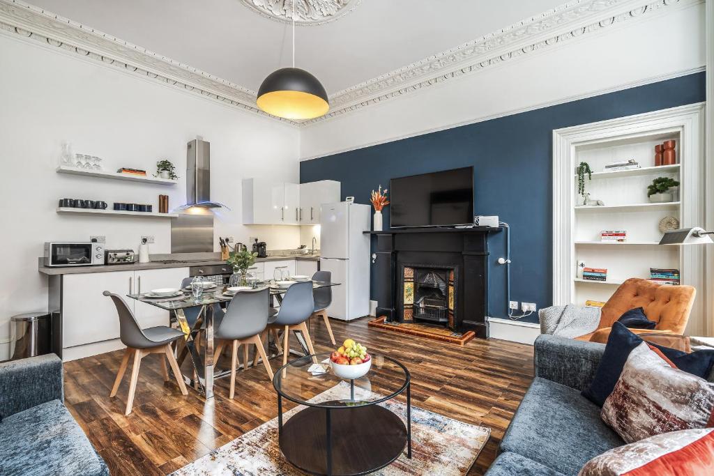 a living room with a couch and a table and a fireplace at The Renfrew Residence 4-bedroom, city centre in Glasgow