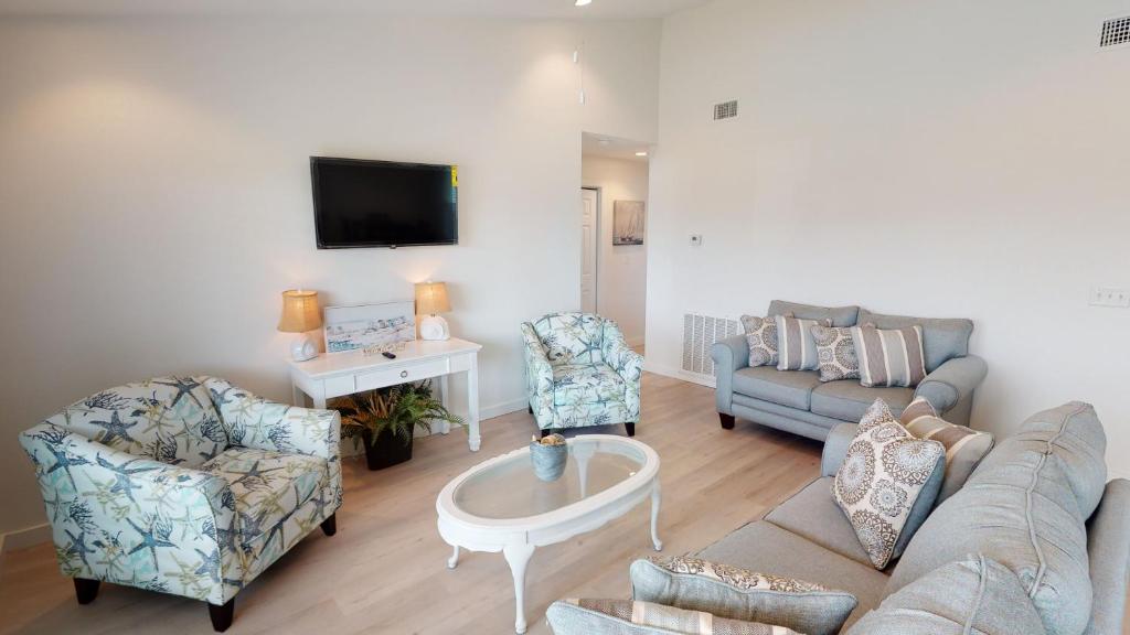 a living room with a couch and chairs and a tv at AH-A202 Second Floor Condo, Newly Remodeled, Overlooks Shared Pool in Port Aransas
