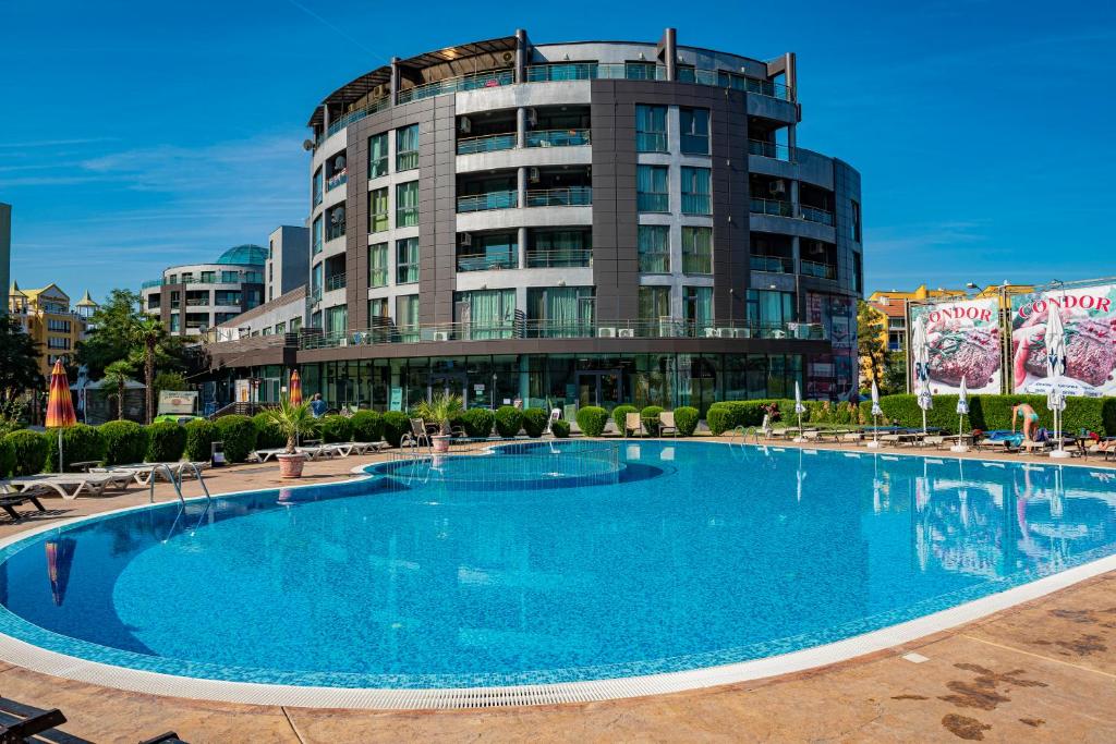 a large swimming pool in front of a building at Menada Sunny Beach Plaza Apartments in Sunny Beach