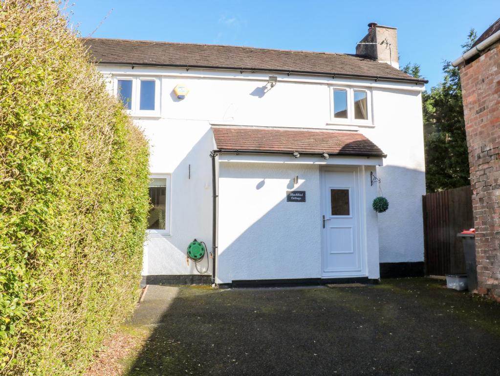 uma garagem branca com uma porta branca em Blackbird Cottage em Telford