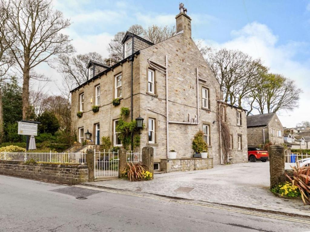 an old stone house on the side of a street at Grassington Lodge in Grassington