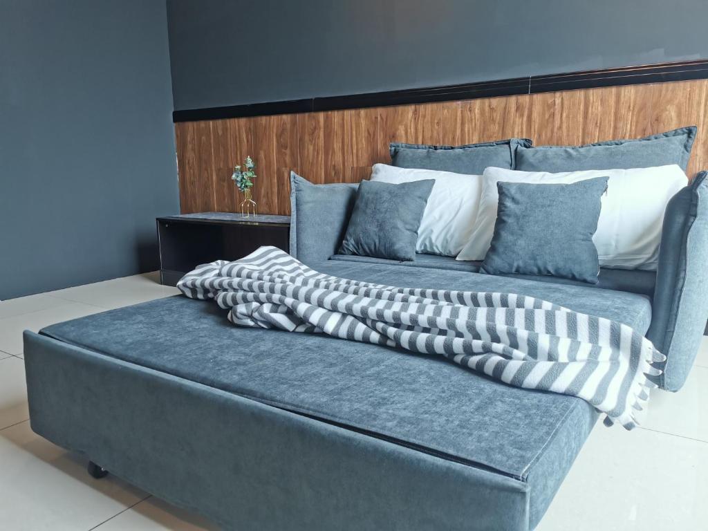 een blauwe bank met twee kussens erop bij OPUS RESIDENCE KL I HomeBrickz in Kuala Lumpur