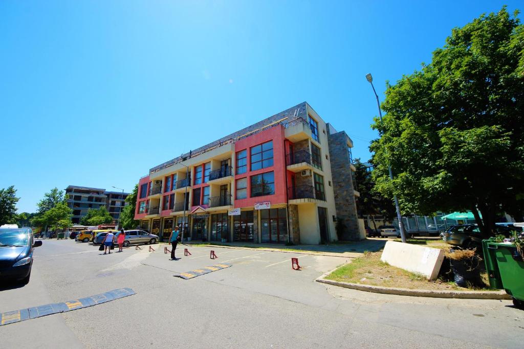 um grupo de pessoas num parque de estacionamento em frente a um edifício em Menada Crystal Park Apartments em Sunny Beach