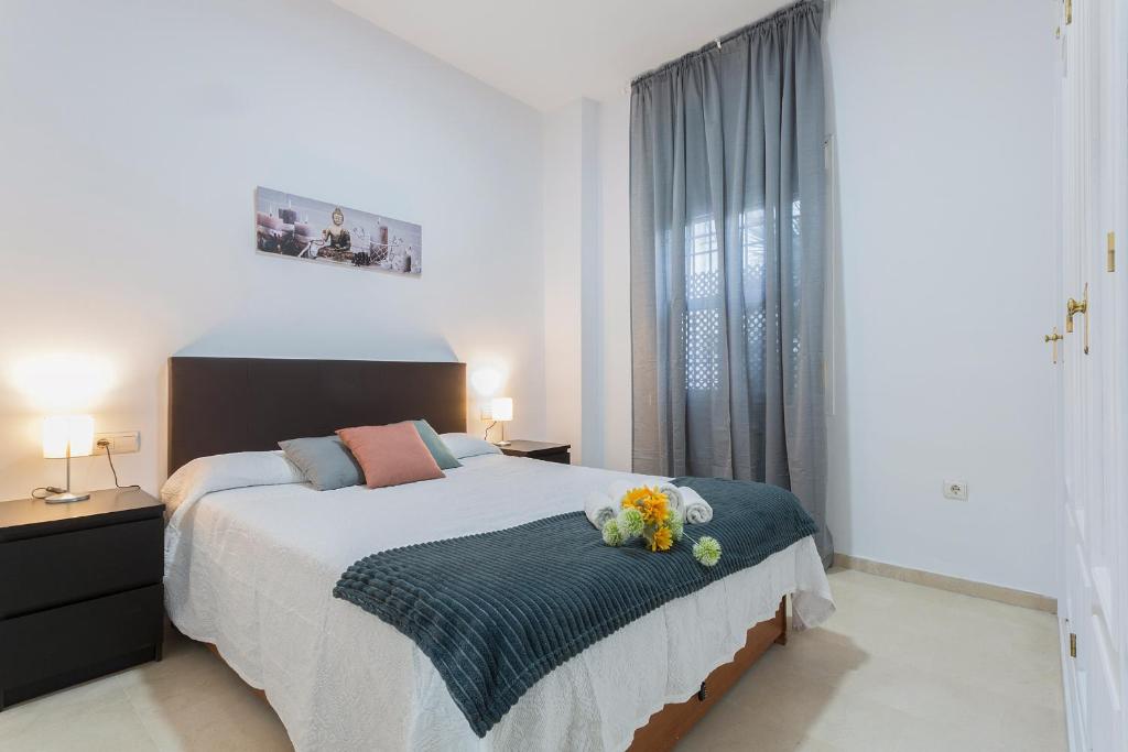 a bedroom with a bed with flowers on it at Centro 4 Rooms 3 baños Parking in Jerez de la Frontera