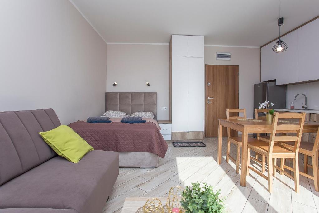 een slaapkamer met een bed en een tafel en een keuken bij Urban Jungle - Sara Apartment in Białystok