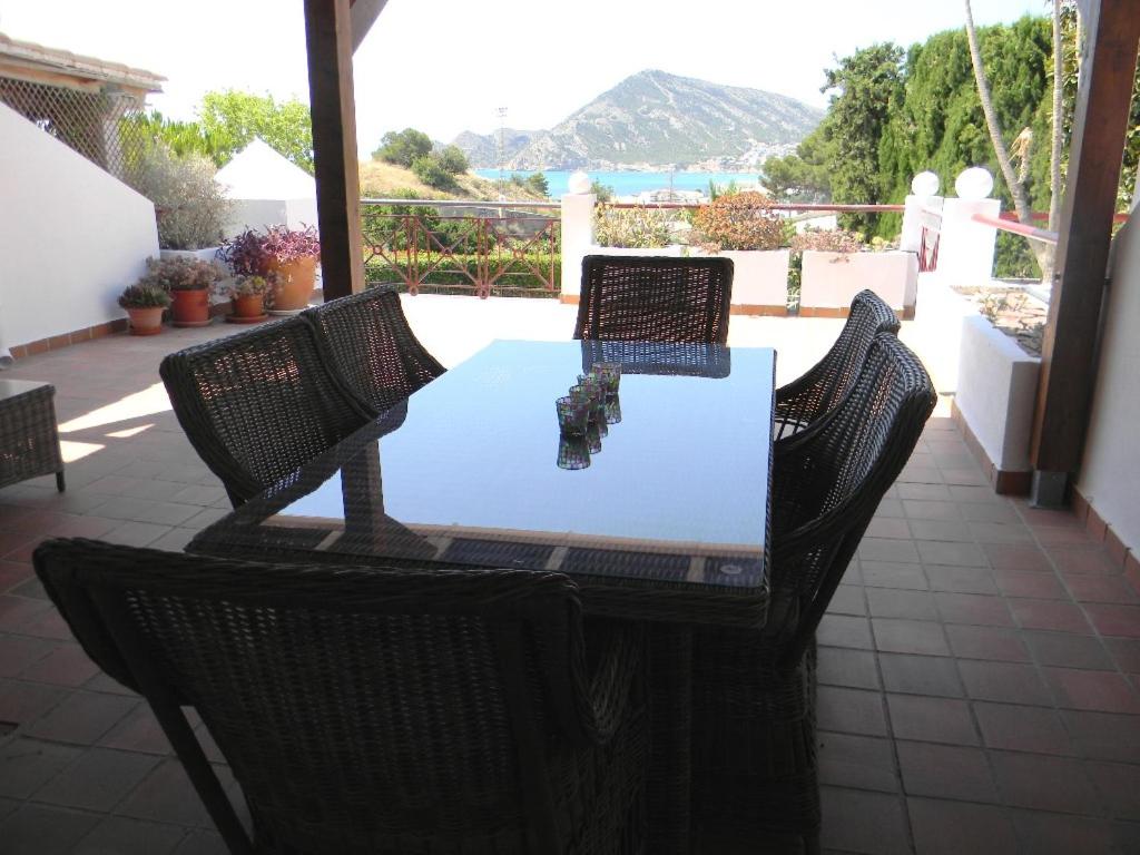 uma mesa e cadeiras num pátio com vista para o oceano em Bonito apartamento con inmensa terraza y piscina em Altea
