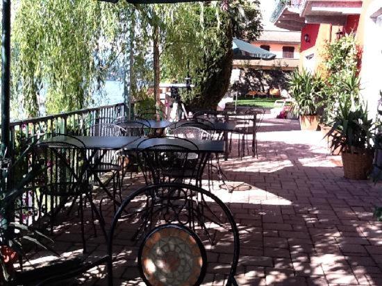 un grupo de mesas y sillas en un patio en B&B Nest on the Lake, en Lezzeno