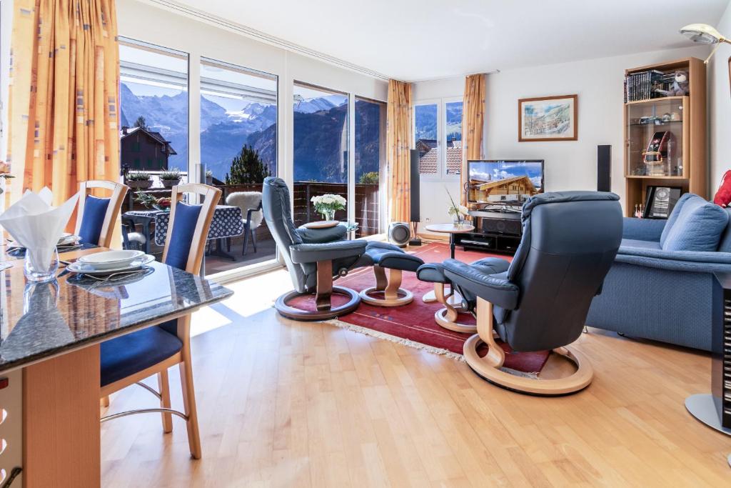 a living room with chairs and a table and a couch at Chalet Hannegg 2 in Wengen
