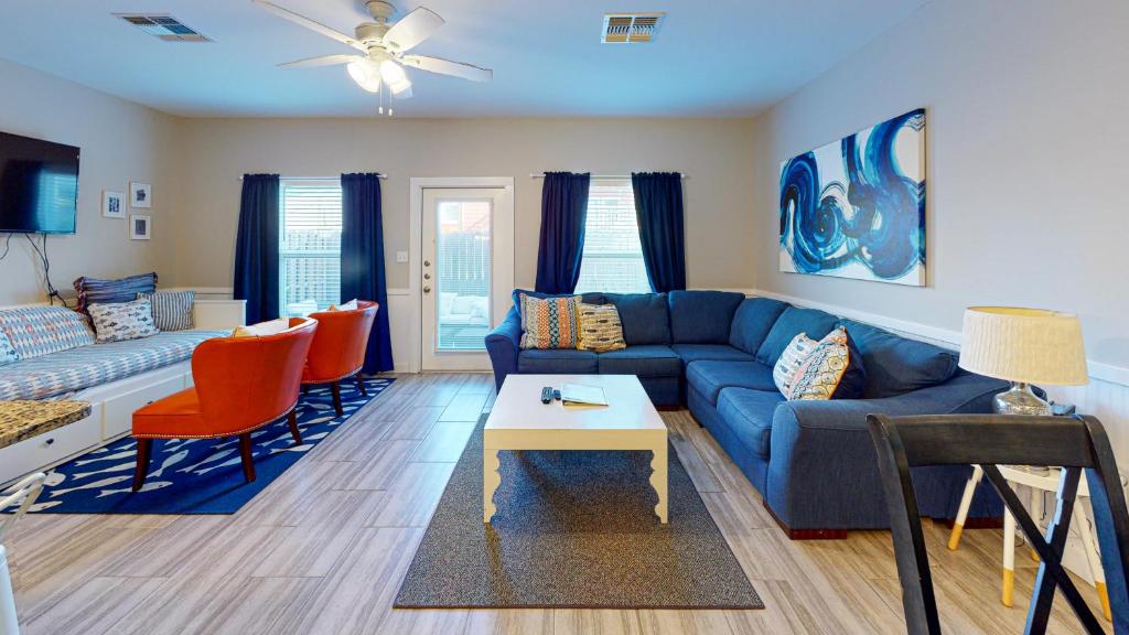 a living room with a blue couch and orange chairs at BC508 Townhome with Beach Inspired Decor, Heated Pool with Water Slide in Port Aransas
