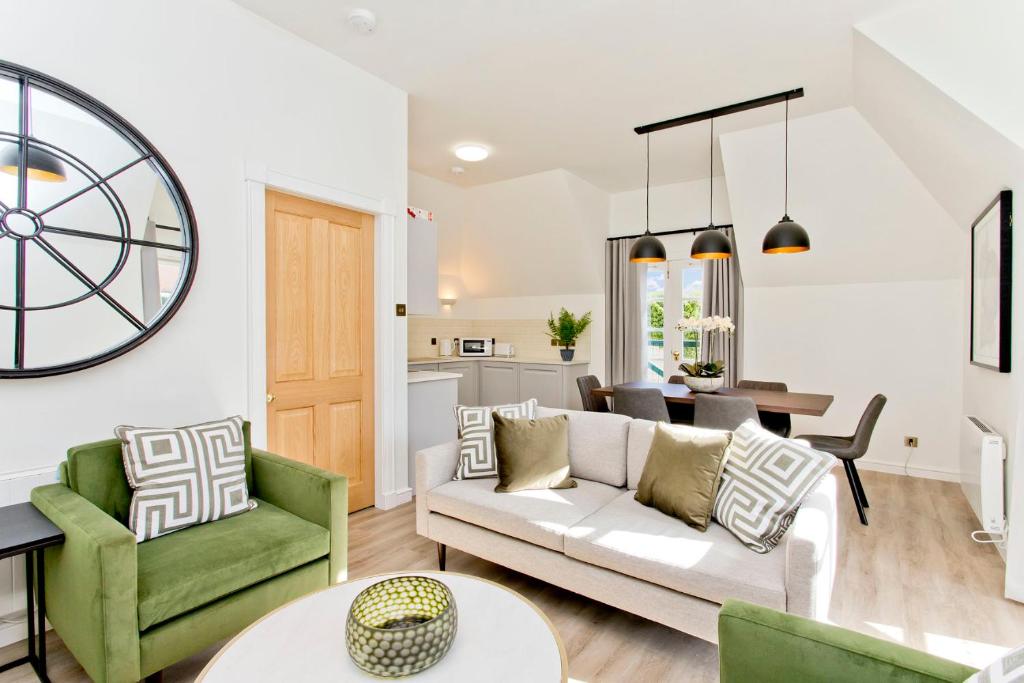 sala de estar con sofá blanco y sillas verdes en Newly Reno'd 2 Bed with Free Parking, en Edimburgo