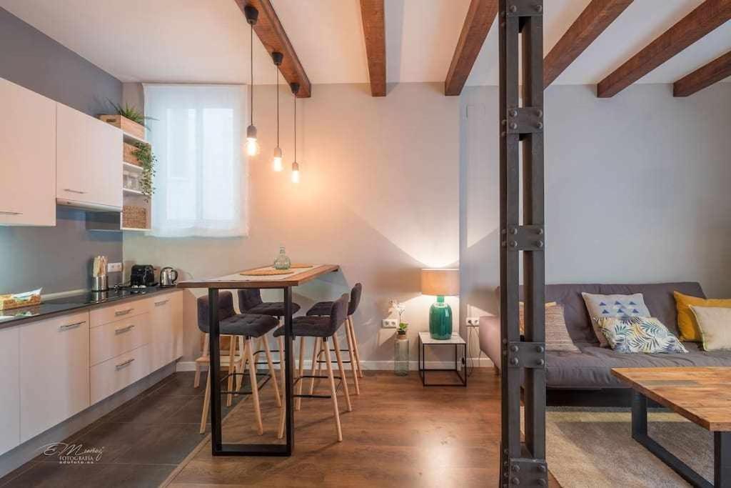 eine Küche und ein Wohnzimmer mit einem Sofa und einem Tisch in der Unterkunft Parking Free - Cathedral Area Apartment in Sevilla