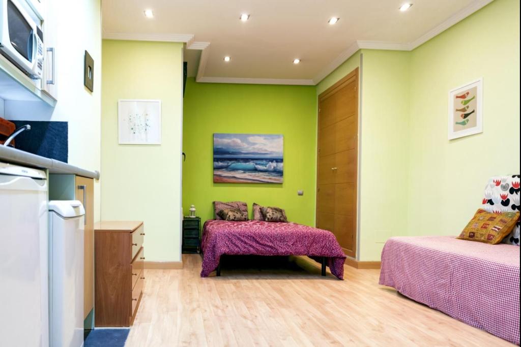 duas camas num quarto com paredes verdes em Suitur Apartment Hita III Centro Madrid em Madri