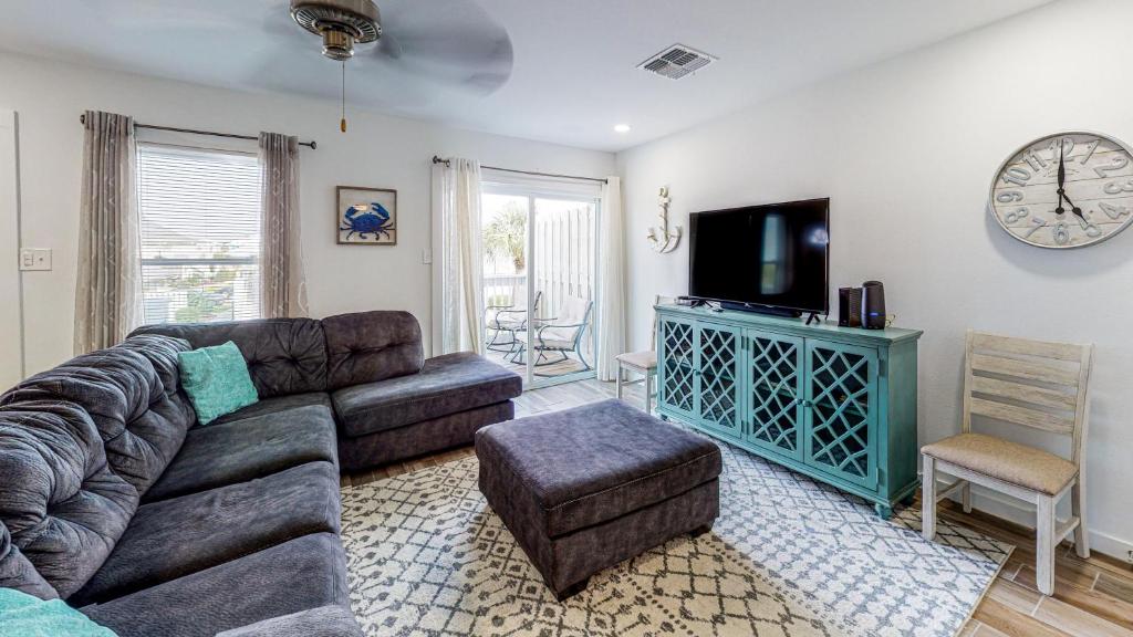 a living room with a couch and a flat screen tv at EC234 Newly Remodeled, One Bedroom, Second Floor Condo, Shared Pool, Grills and Boardwalk in Port Aransas