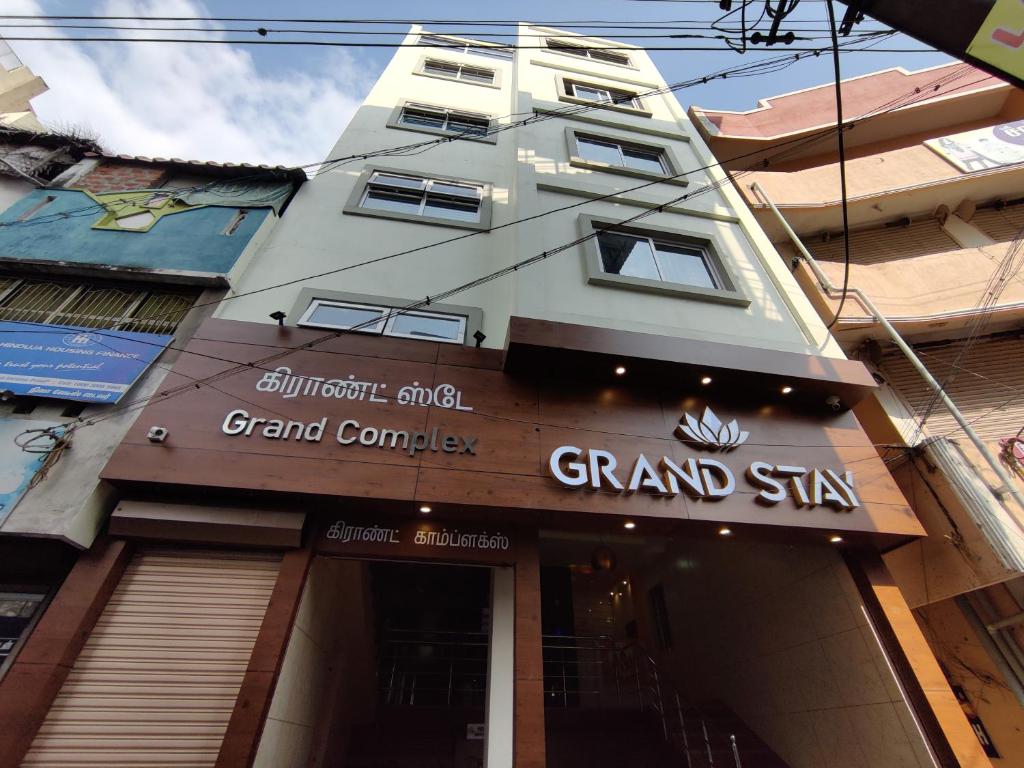 Um edifício alto com um grande cartaz da empresa. em Hotel Grand Stay em Tiruchchirappalli