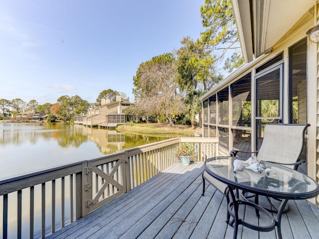 a deck with a glass table and a chair at Fishermans Cove 45, WiFi, End Unit, 2 Bedrooms, Sleeps 6 in Ponte Vedra