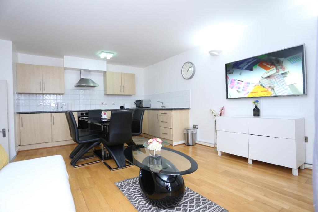 a living room with a table and a kitchen at Gorgeous 2 bedroom 2 bathroom Woolwich in Woolwich