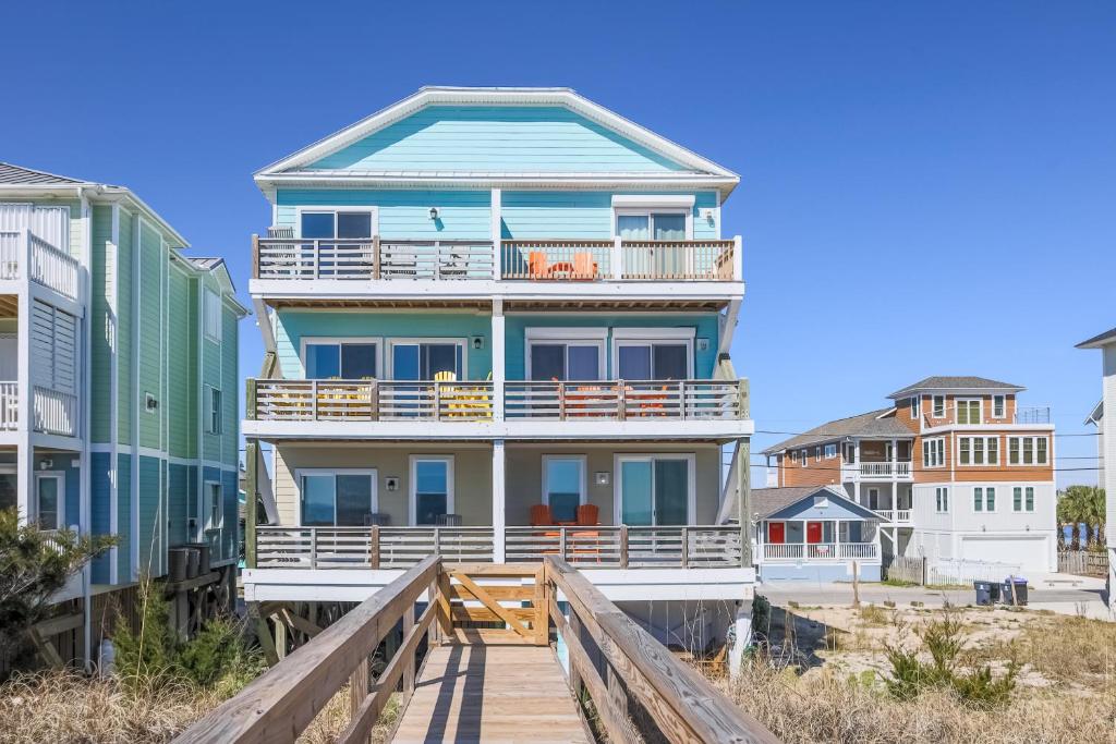 Una casa grande en la playa con un paseo marítimo de madera en Paradise Island Ocean Front, en Carolina Beach