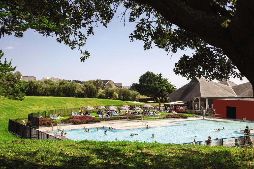 ein großer Swimmingpool mit Menschen auf einem Feld in der Unterkunft Belambra Clubs Guidel - Les Portes De L'Océan in Guidel-Plage