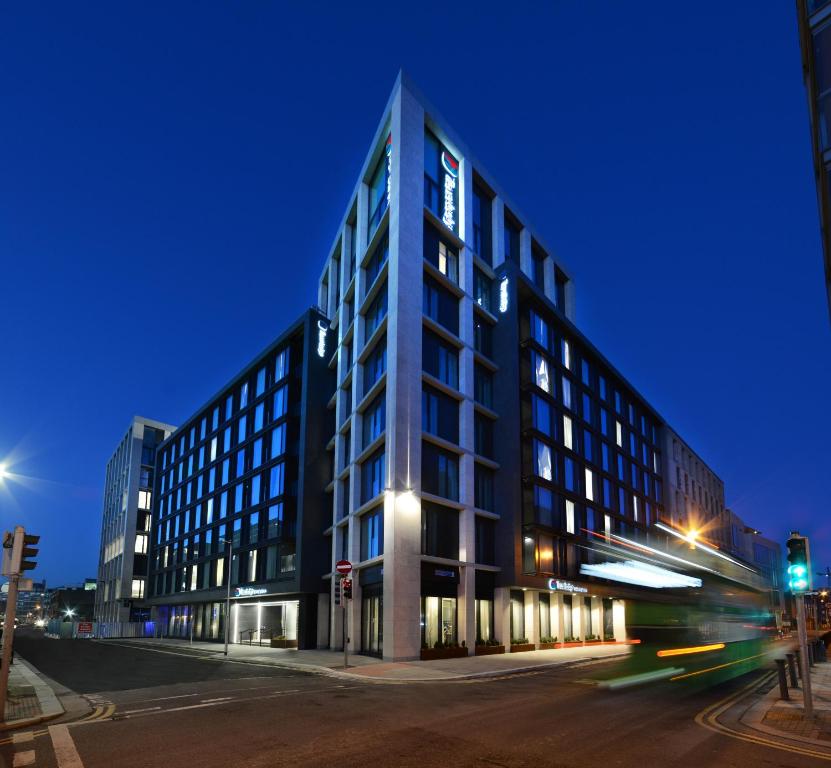 um edifício alto numa rua da cidade à noite em Travelodge PLUS Dublin City Centre em Dublin