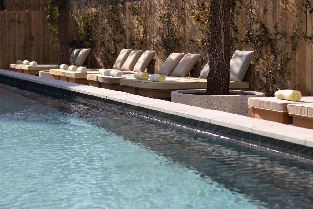 - une rangée de chaises longues à côté de la piscine dans l'établissement MOB House, à Saint-Ouen