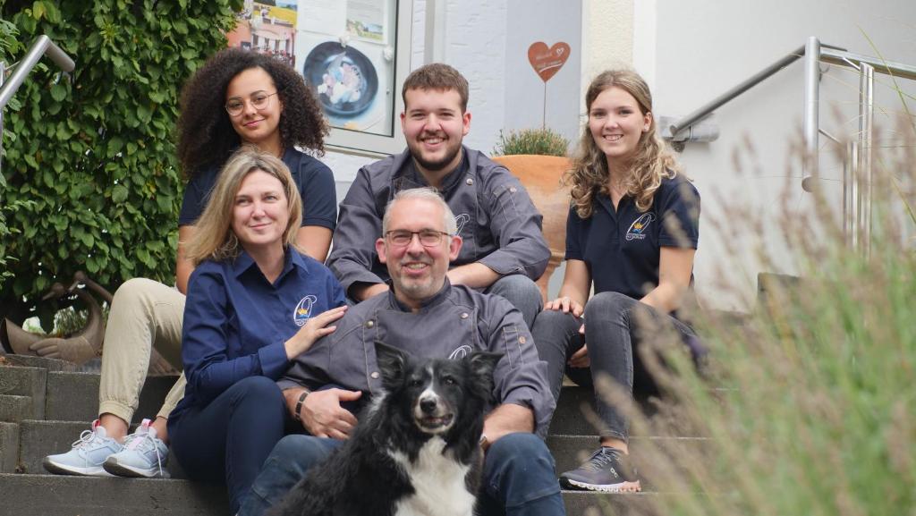 un grupo de personas sentadas en las escaleras con un perro en Landhotel Zum Kronprinzen, en Oberwesel